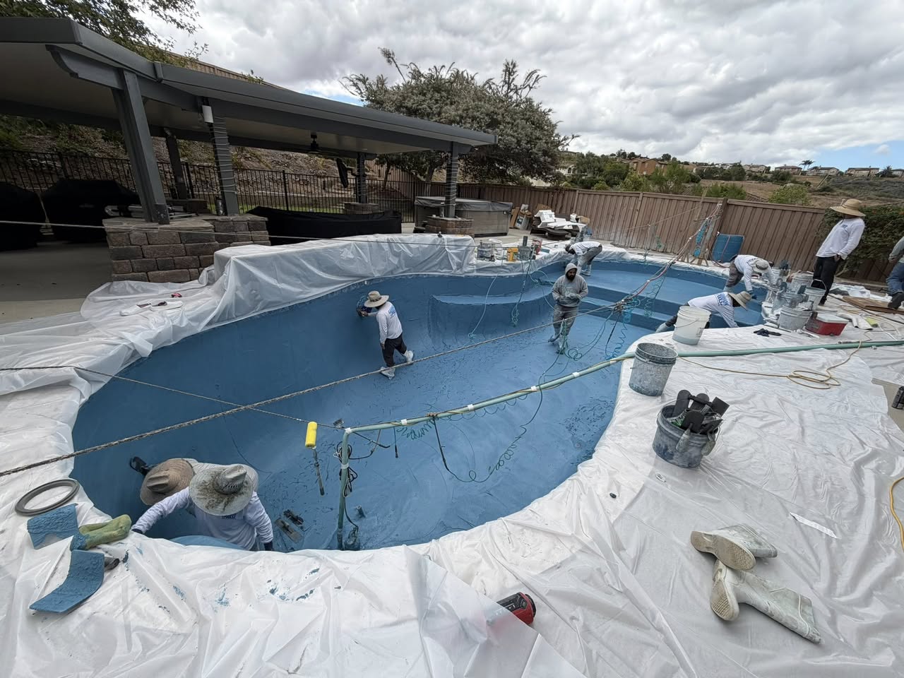 Crew applying plaster finish to a new pool